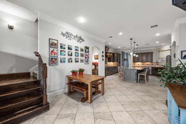 tiled dining area featuring ornamental molding