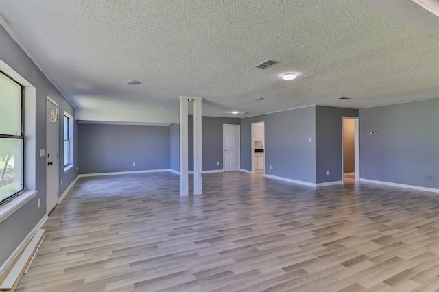 unfurnished room with a textured ceiling and light hardwood / wood-style floors