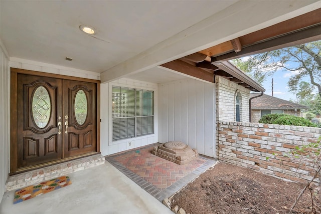 view of exterior entry featuring covered porch