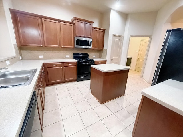 kitchen with backsplash, sink, black appliances, light tile patterned floors, and a kitchen island