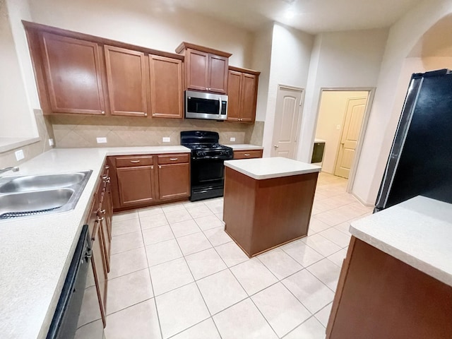 3238 Doves Nest Ct, Dickinson, TX 77539 - kitchen with black appliances, a sink, backsplash, light countertops, and a center island