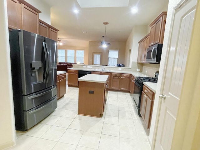 kitchen featuring a center island, black appliances, sink, ceiling fan, and kitchen peninsula