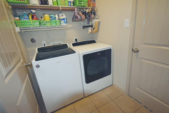 clothes washing area featuring light tile patterned floors and washing machine and clothes dryer