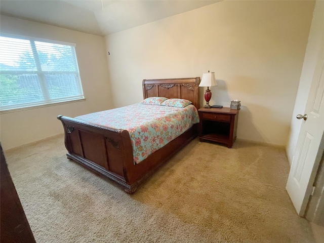 bedroom with a tray ceiling and light carpet