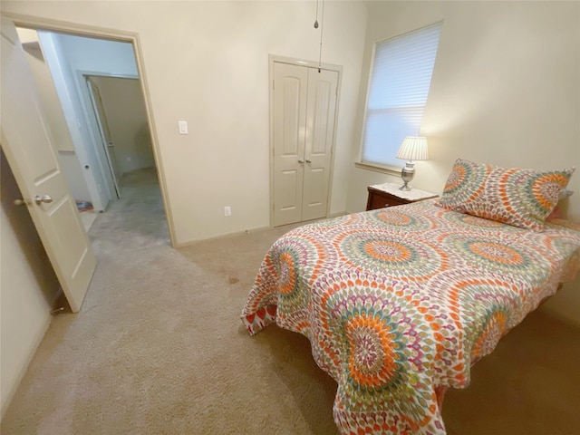 bedroom featuring light colored carpet and a closet