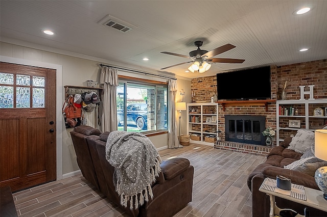 living room with ceiling fan and a fireplace