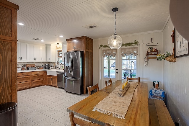 kitchen featuring french doors, sink, hanging light fixtures, stainless steel appliances, and light tile patterned flooring