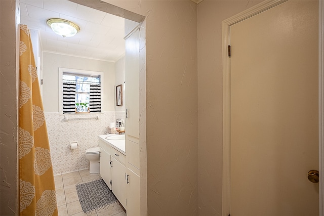 bathroom featuring vanity, crown molding, tile walls, tile patterned flooring, and toilet