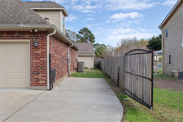 view of side of property with a yard and central AC unit