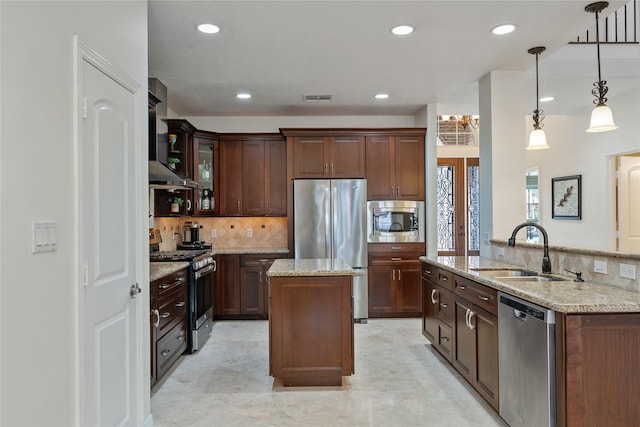 kitchen featuring pendant lighting, sink, dark brown cabinets, a kitchen island, and stainless steel appliances