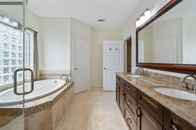 bathroom featuring tile patterned floors, tiled tub, and vanity