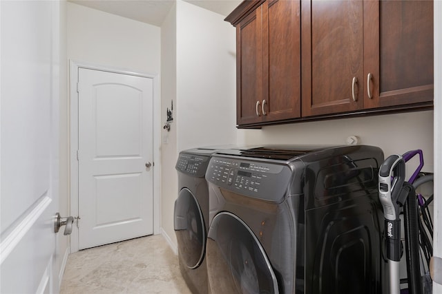 laundry room with washing machine and clothes dryer and cabinets