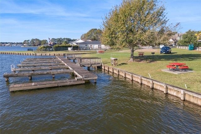 view of dock featuring a water view and a lawn