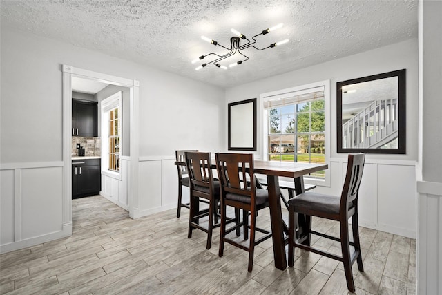 dining room with a chandelier and a textured ceiling