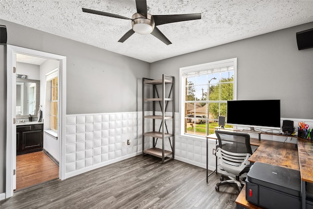 office space featuring hardwood / wood-style flooring, ceiling fan, and a textured ceiling