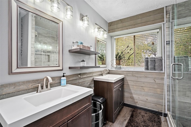 bathroom with vanity, wood-type flooring, a textured ceiling, and walk in shower