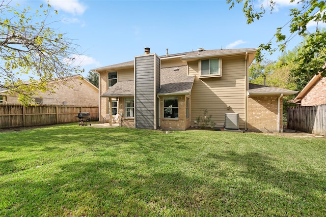 back of house featuring a lawn and a patio area