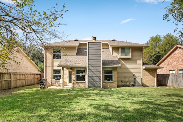 rear view of property with a lawn, central AC, and a patio area