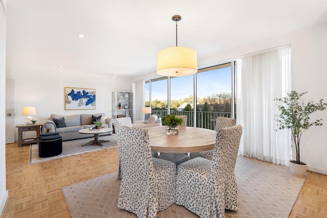 dining space featuring expansive windows and light parquet floors