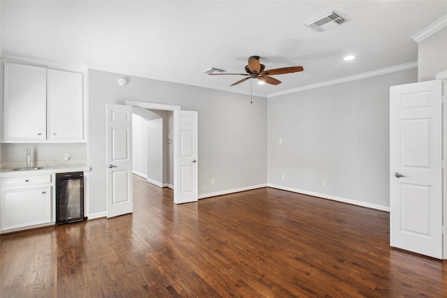 interior space featuring ceiling fan, dark wood-type flooring, indoor wet bar, crown molding, and wine cooler