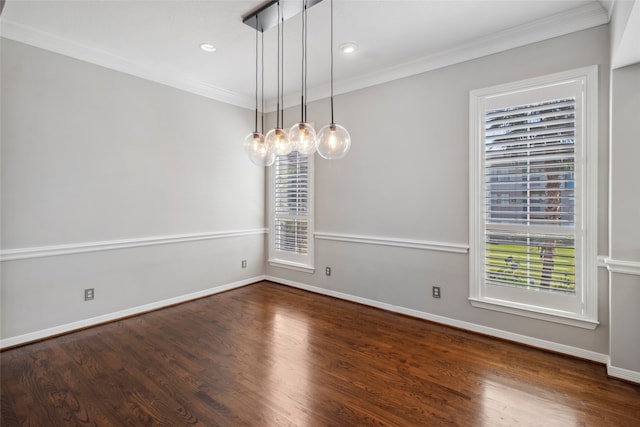 spare room featuring crown molding, plenty of natural light, and dark wood-type flooring