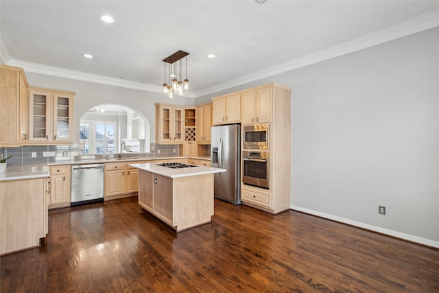 kitchen featuring sink, pendant lighting, decorative backsplash, a kitchen island, and appliances with stainless steel finishes