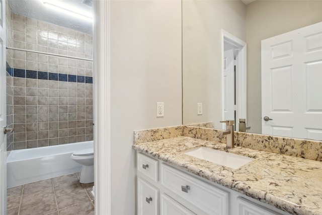 full bathroom featuring tile patterned floors, vanity, tiled shower / bath combo, and toilet