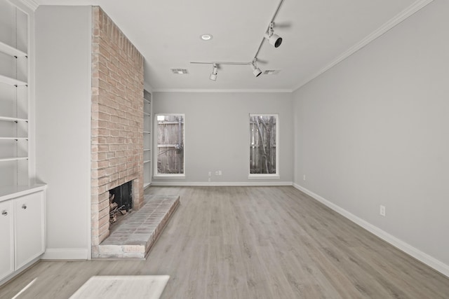 unfurnished living room featuring light wood finished floors, baseboards, built in features, crown molding, and a fireplace