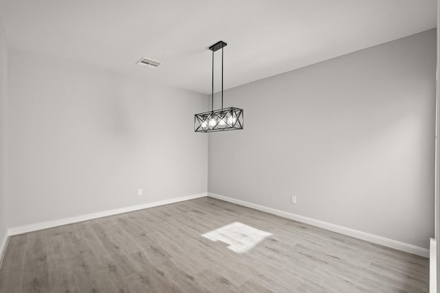 unfurnished dining area with visible vents, light wood-style flooring, and baseboards