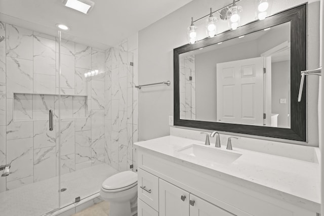 bathroom with toilet, a marble finish shower, and vanity