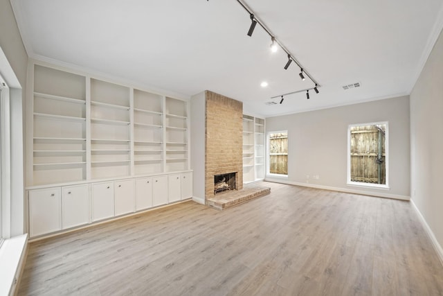 unfurnished living room with light wood-type flooring, a brick fireplace, baseboards, and built in features