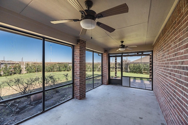 unfurnished sunroom featuring ceiling fan