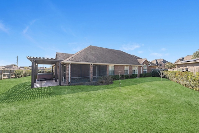 rear view of property with a yard, a pergola, and a hot tub