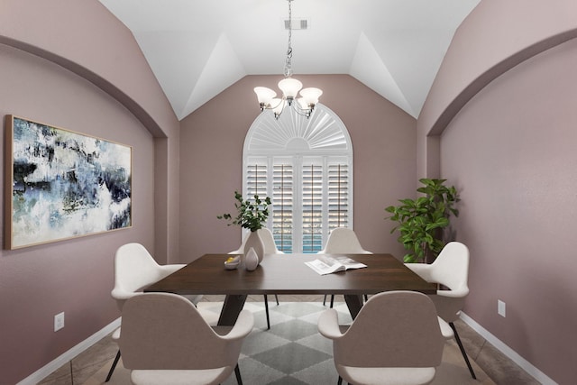 tiled dining space with a chandelier and vaulted ceiling