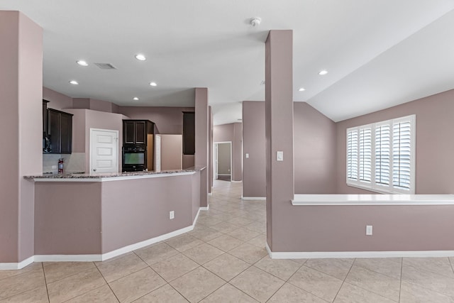 kitchen featuring lofted ceiling, light tile patterned floors, black oven, light stone counters, and kitchen peninsula