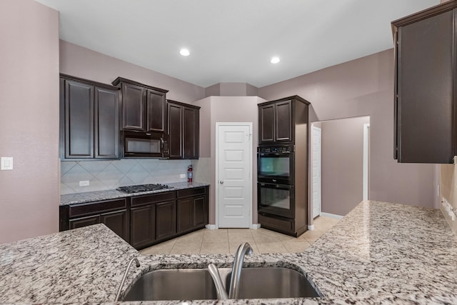 kitchen with light stone countertops, sink, backsplash, and black appliances