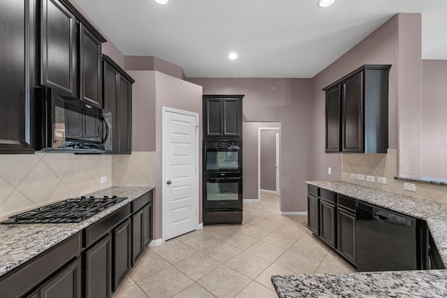 kitchen with backsplash, light stone counters, light tile patterned floors, and black appliances