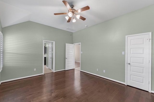 unfurnished bedroom featuring connected bathroom, dark wood-type flooring, ceiling fan, and lofted ceiling