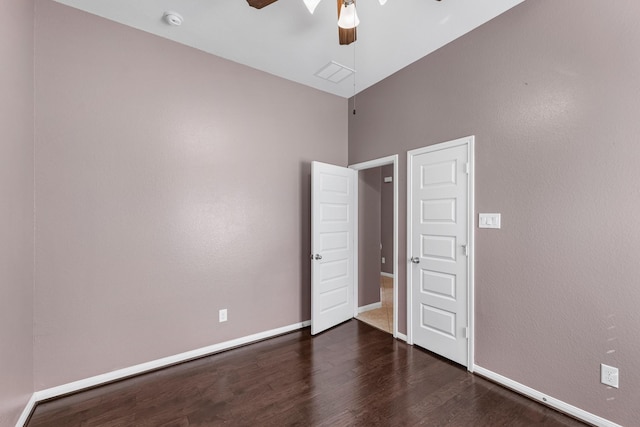 unfurnished bedroom featuring ceiling fan and dark hardwood / wood-style flooring