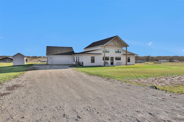 modern farmhouse style home featuring central air condition unit, a front yard, and a garage