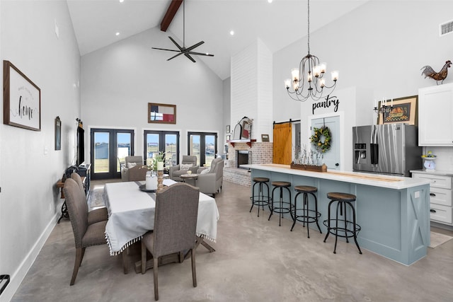 dining room with french doors, ceiling fan with notable chandelier, beam ceiling, a barn door, and high vaulted ceiling