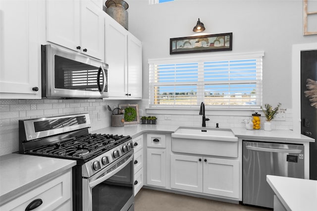 kitchen featuring decorative backsplash, appliances with stainless steel finishes, white cabinetry, and sink