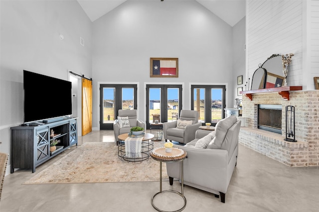 living room featuring a barn door, french doors, high vaulted ceiling, and a brick fireplace