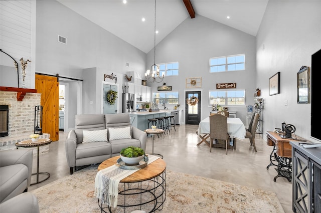 living room with beamed ceiling, a barn door, an inviting chandelier, and high vaulted ceiling