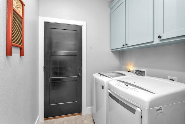 washroom with cabinets and washer and clothes dryer