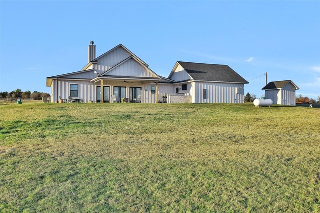 back of house with a lawn and an outbuilding