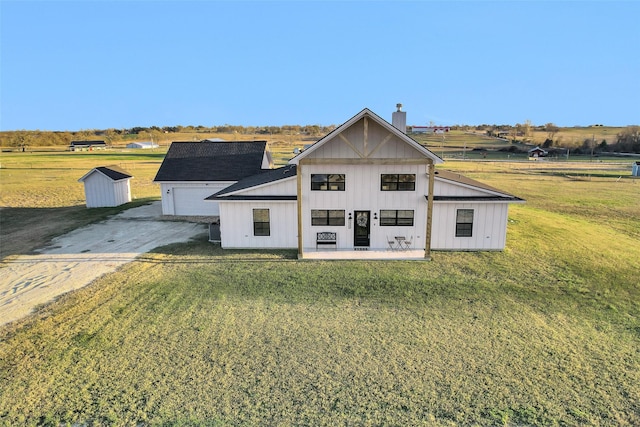 exterior space featuring a rural view, central AC, a front yard, a garage, and covered porch