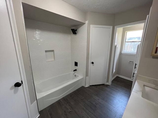 bathroom with vanity, shower / tub combination, a textured ceiling, and hardwood / wood-style flooring