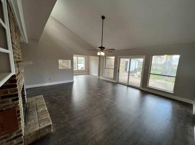 unfurnished living room with ceiling fan, dark hardwood / wood-style floors, lofted ceiling, and a brick fireplace