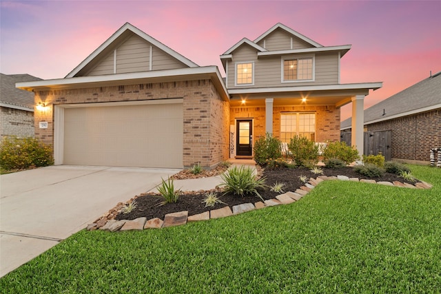 craftsman-style home featuring a lawn, a garage, and covered porch